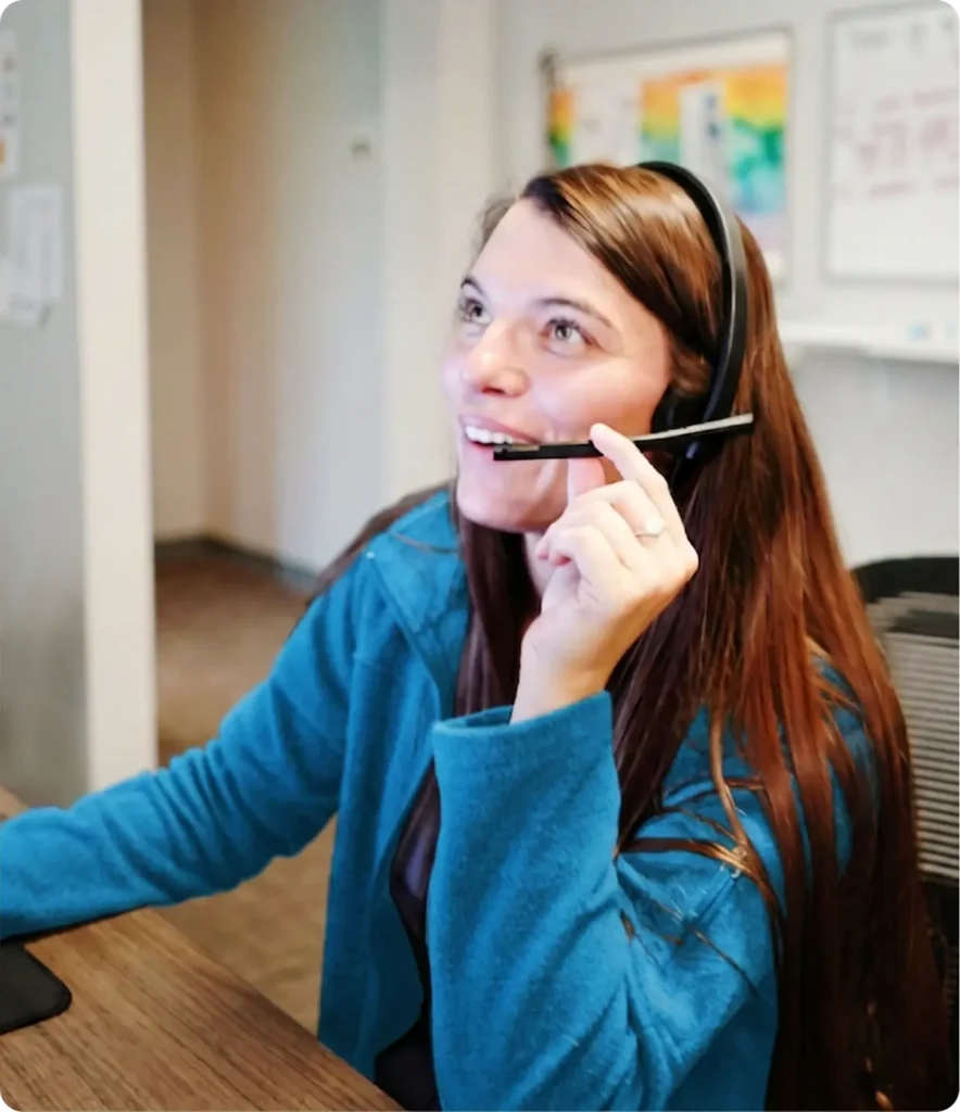 VirtuAlly healthcare team member using a headset and computer to support virtual nursing program implementation and clinical operations.