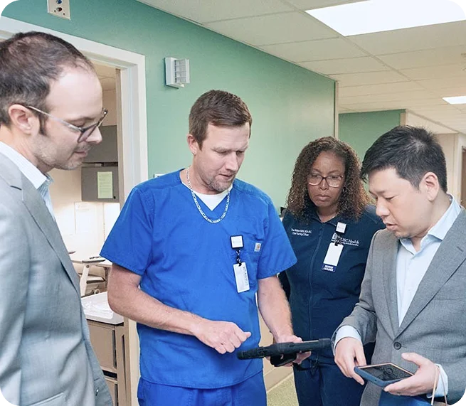 Healthcare professionals collaborating in a hospital setting to improve bedside nursing workflows and patient care through virtual nursing.