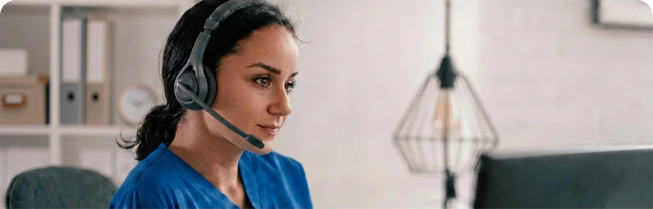VirtuAlly virtual nurse wearing blue scrubs and a headset, providing remote clinical support to hospital care teams.
