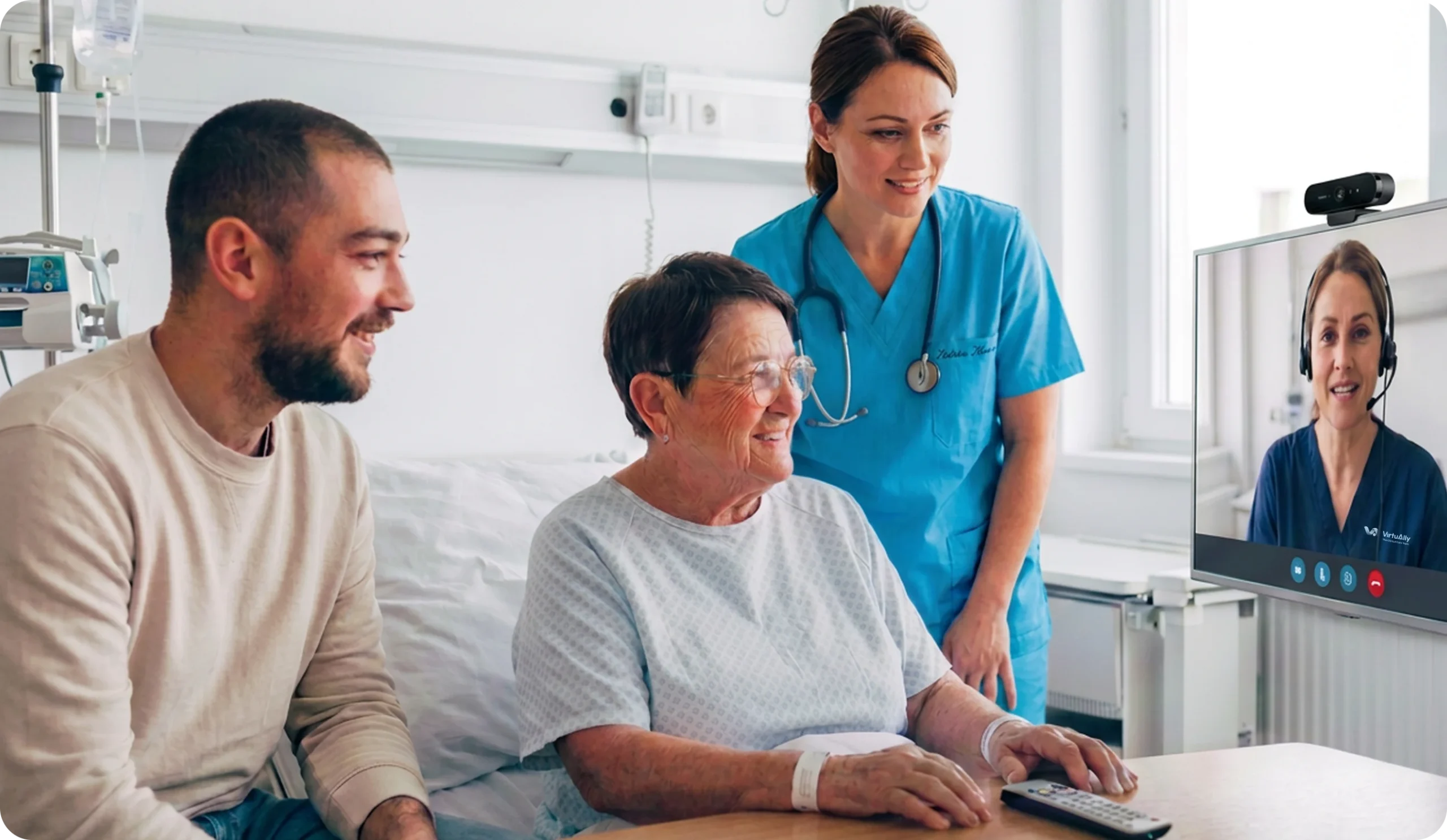 Hospital patient receiving coordinated care from bedside nurses and a remote healthcare clinician through a virtual consultation screen.